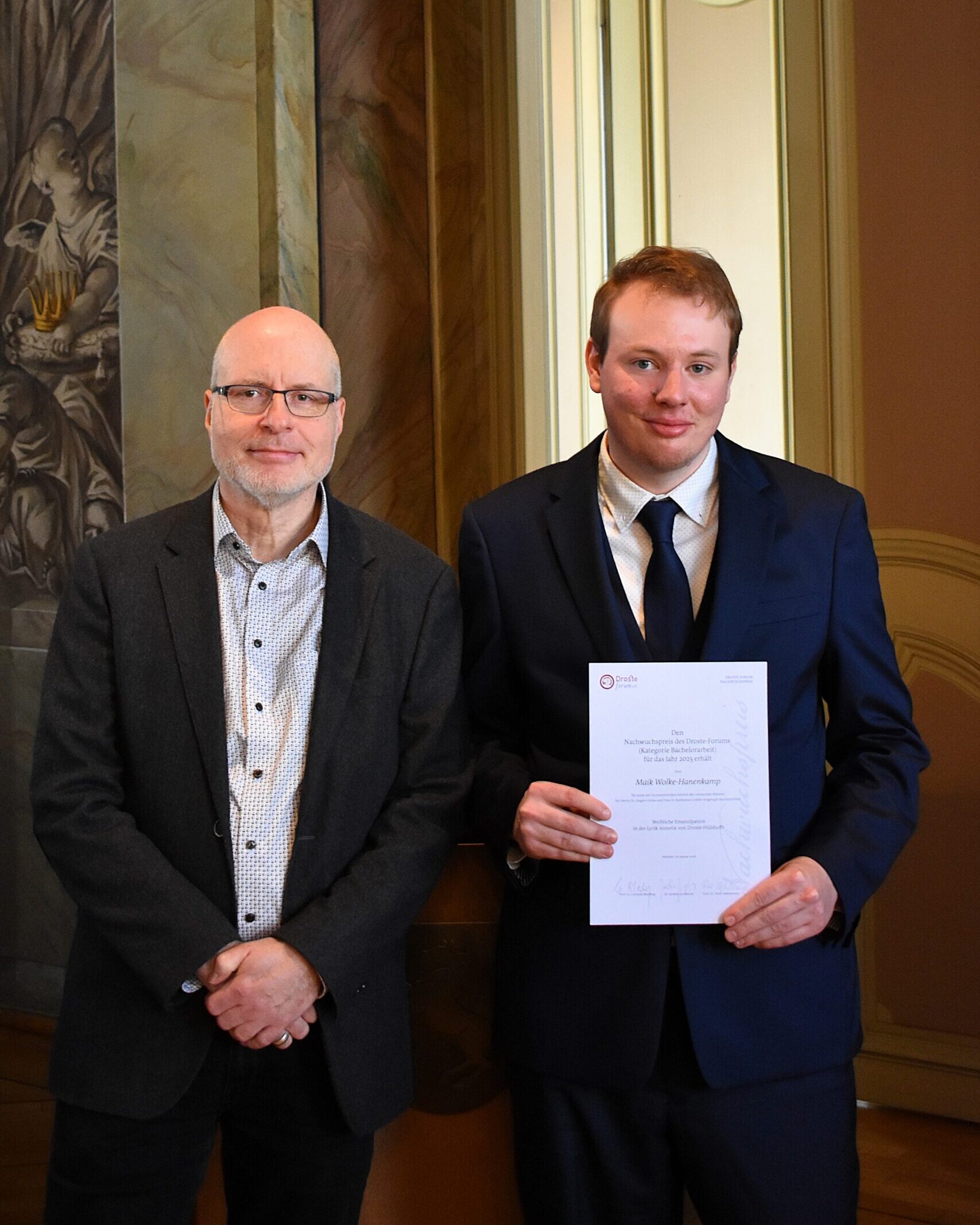 Foto-Bachelorarbeit-Verleihung-Nachwuchspreis-Droste-Forum-2025 Foto Preistraeger des Nachwuchspreises 2025 für seine Bachelorarbeit Maik Wolke-Hanenkamp und sein Betreuer Doktor Juergen Gunia